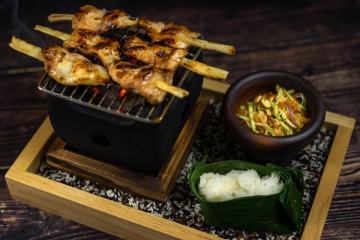 Moo Ping&nbsp;– Pork jowl on sugar cane sticks grilled live over burning coals